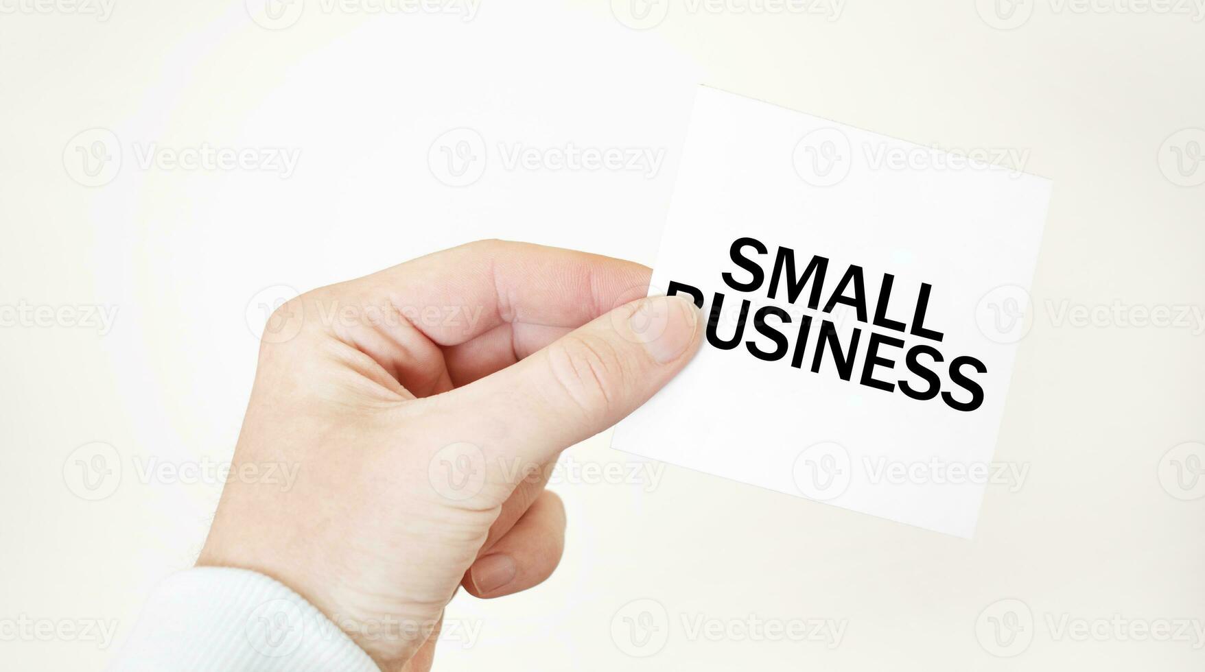 Businessman holding a card with text SMALL BUSINESS, business concept photo