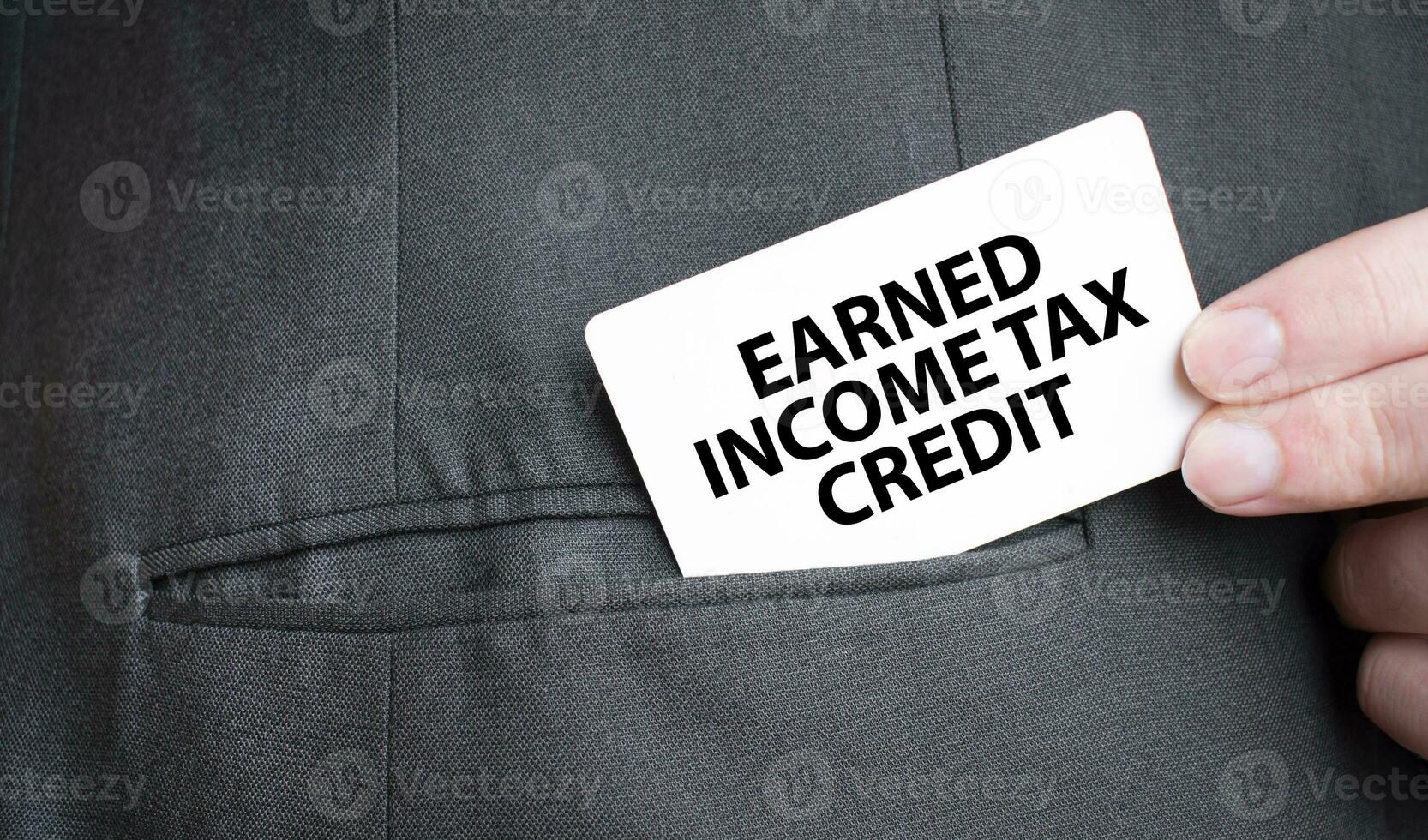 Card with EARNED INCOME TAX CREDIT text in pocket of businessman suit. Investment and decisions business concept. photo