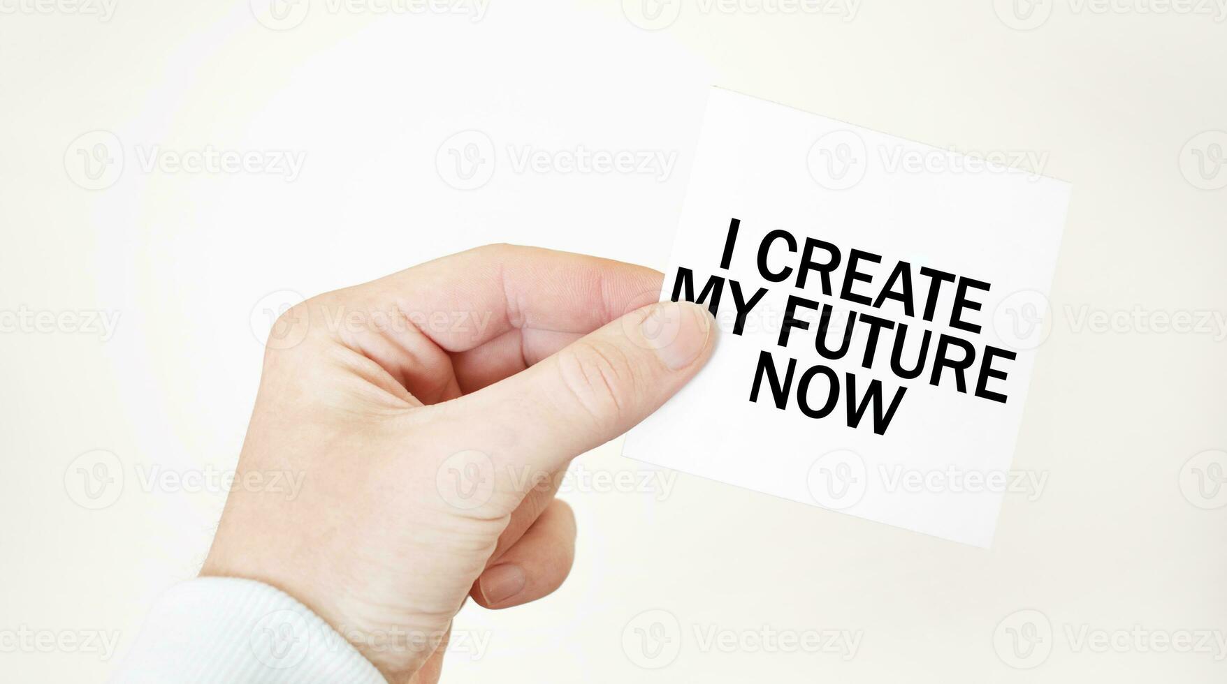 Businessman holding a card with text I CREATE MY FUTURE NOW, business concept photo