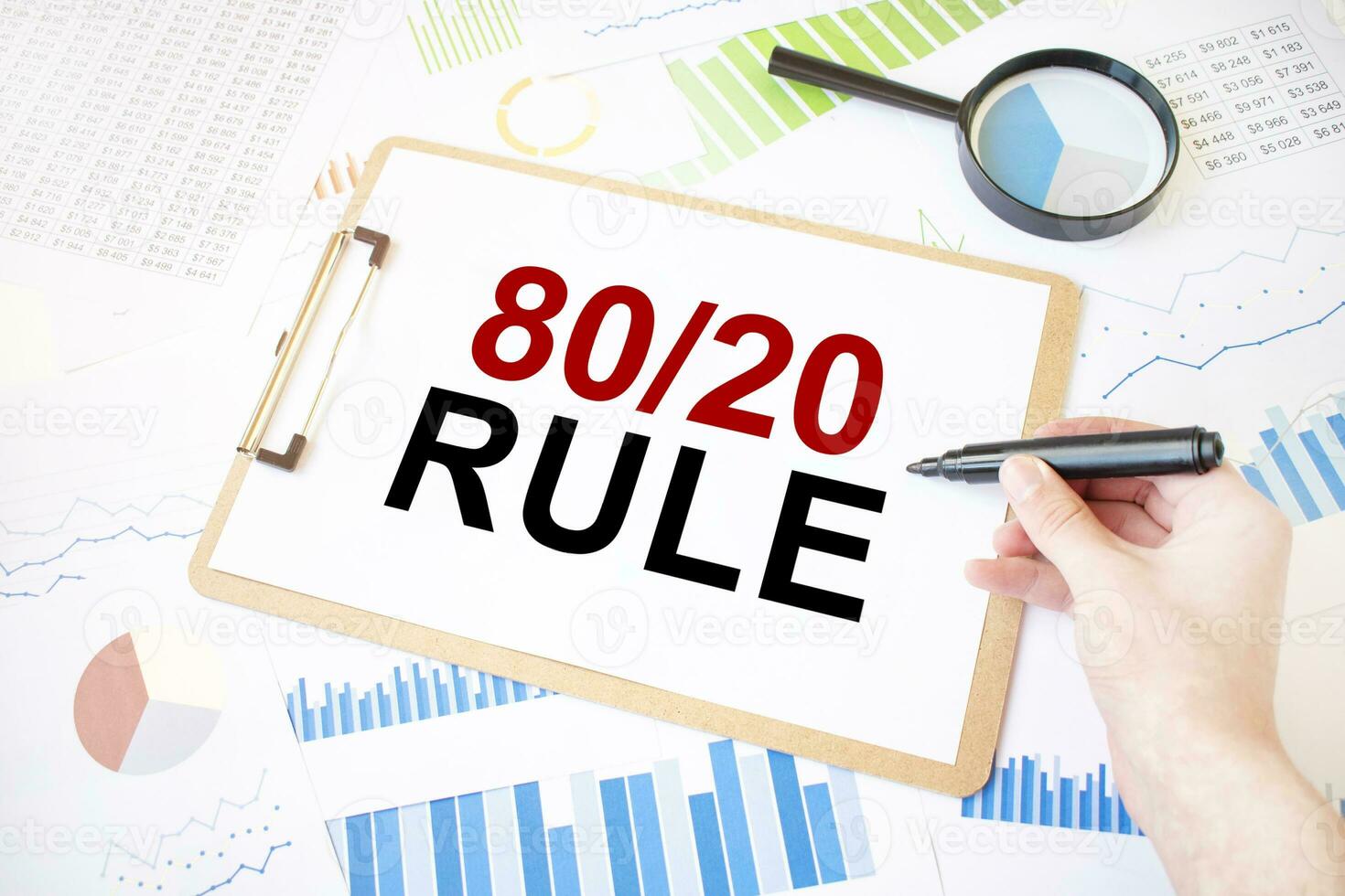 Text 80 and 20 rule on white paper sheet and marker on businessman hand on the diagram. Business concept photo