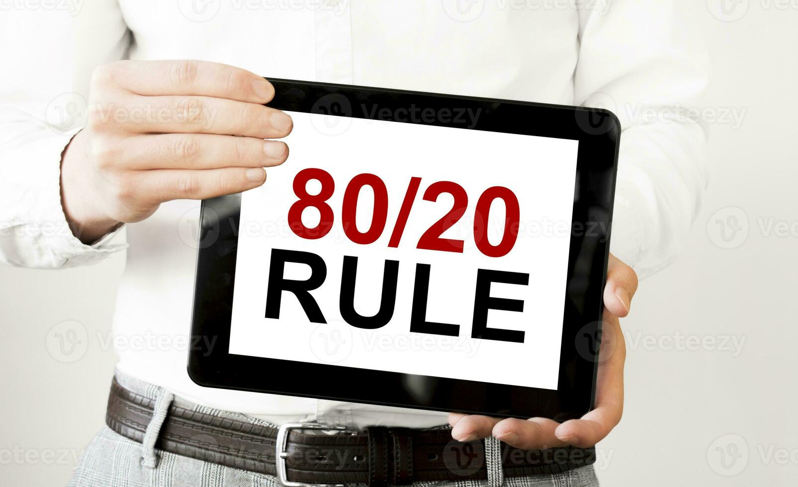 Text 80 and 20 rule on tablet display in businessman hands on the white background. Business concept photo