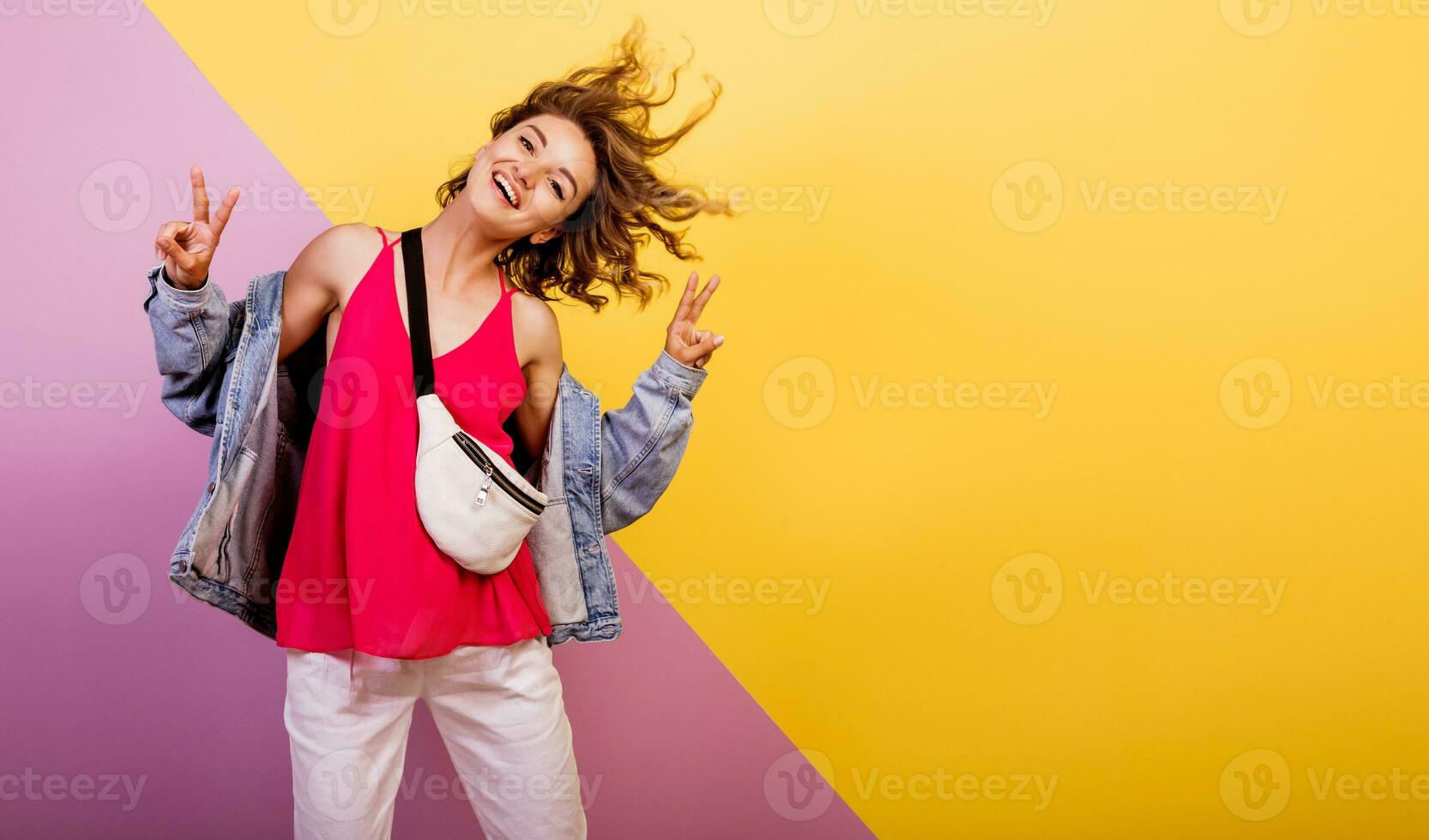 Funny woman with short wavy hairs dancing and having fun on multicolor background.   Copy space for text. photo