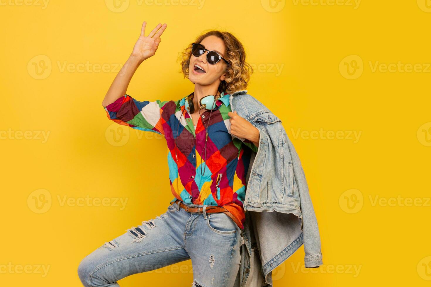 Pretty   European  woman in blue dress holding bouquet of flowers over yellow background. Straw hat. Summer mood. photo