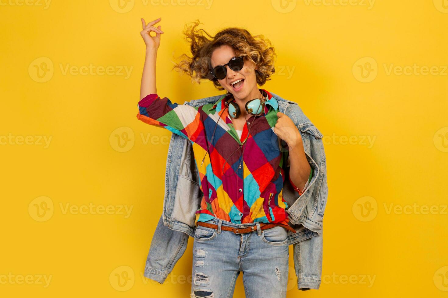 Pretty   European  woman in blue dress holding bouquet of flowers over yellow background. Straw hat. Summer mood. photo