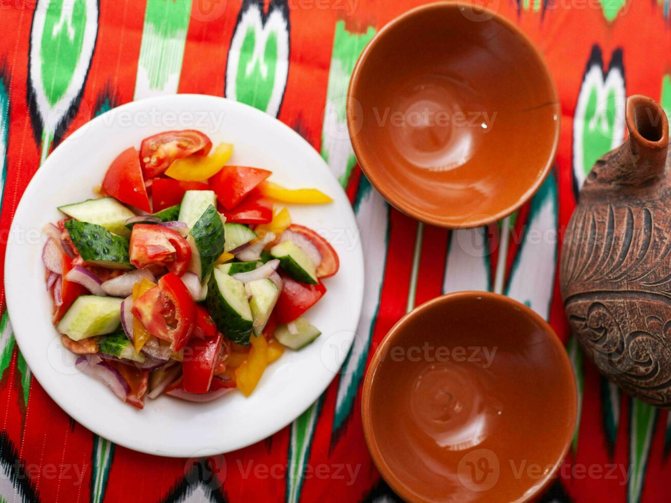 Tomato, cucumber, sweet pepper and onion salad, seasoned with oil. Asian style photo