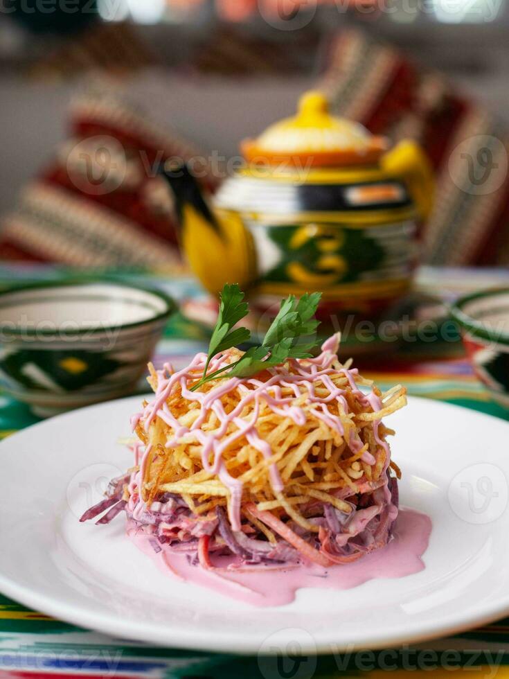 Capercaillie nest salad made of beets, pie potatoes, markovi and greens, topped with mayonnaise. Asian style photo