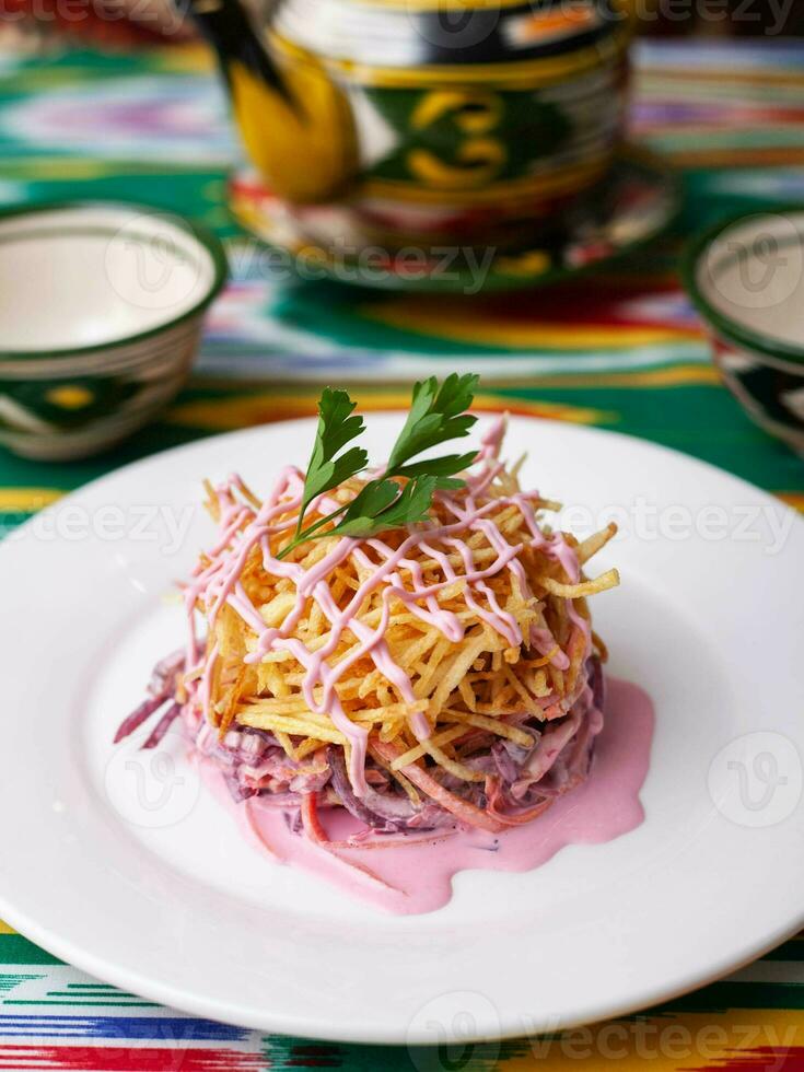 Capercaillie nest salad made of beets, pie potatoes, markovi and greens, topped with mayonnaise. Asian style photo