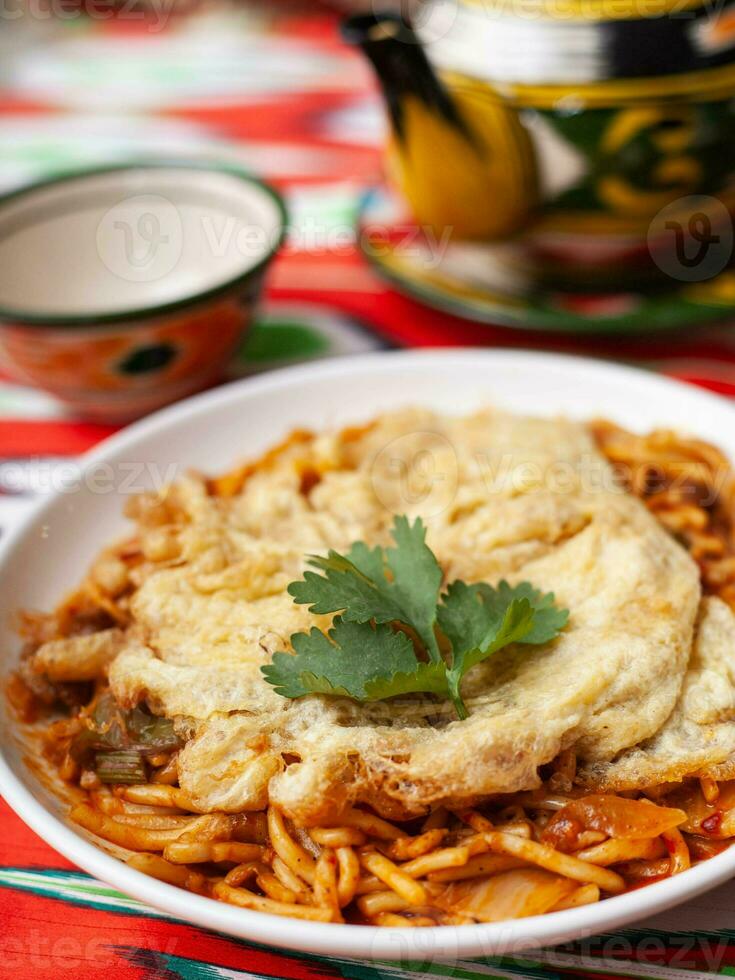 The oriental lagman dish is homemade noodles fried with meat, vegetables and herbs. Eastern cuisine photo