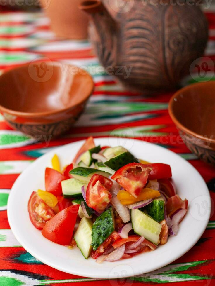 Tomato, cucumber, sweet pepper and onion salad, seasoned with oil. Asian style photo