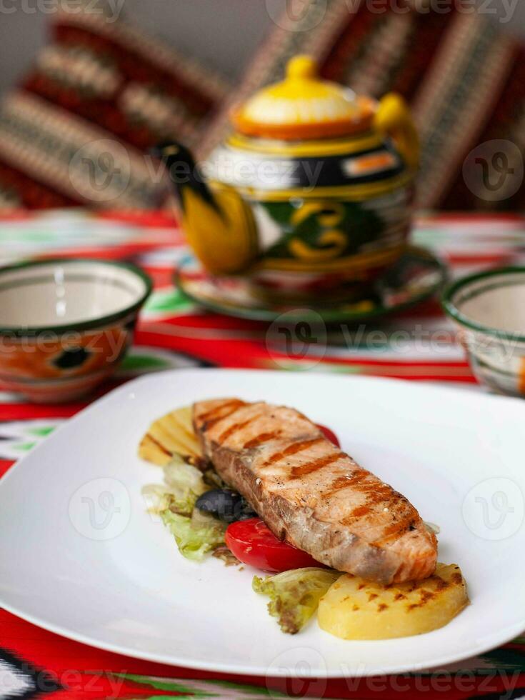 Salmon steak on a pillow of stewed vegetables. Asian style photo