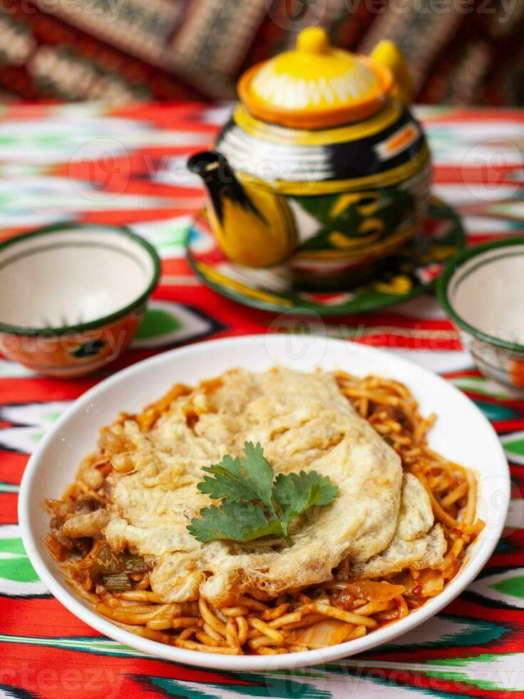 The oriental lagman dish is homemade noodles fried with meat, vegetables and herbs. Eastern cuisine photo