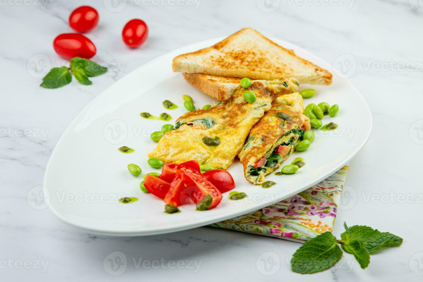 Breakfast of eggs and vegetables with cherry tomatoes and slices of bread in a white plate side view photo