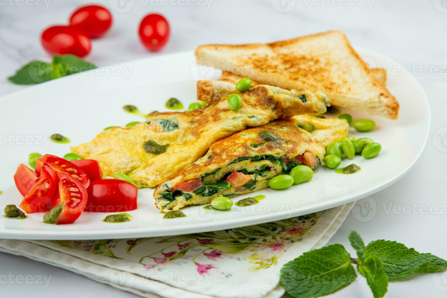 Breakfast of eggs and vegetables with cherry tomatoes and slices of bread in a white plate side view photo