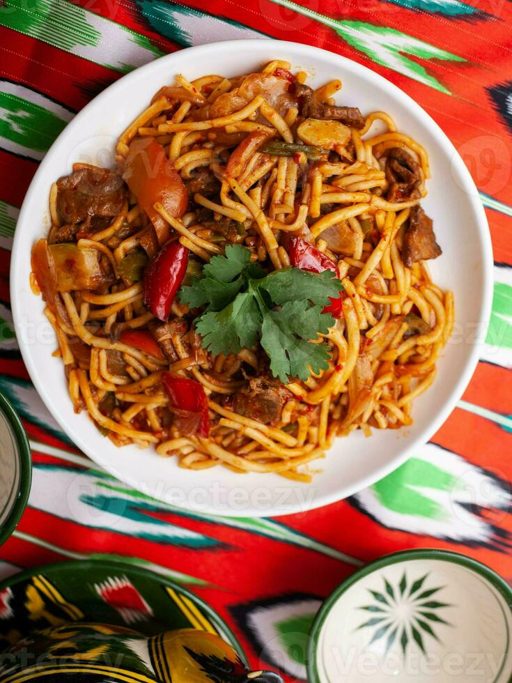 The oriental lagman dish is homemade noodles fried with meat, vegetables and herbs. Eastern cuisine photo