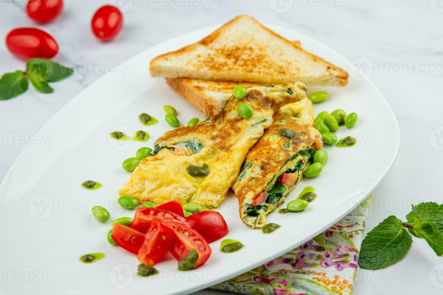 Breakfast of eggs and vegetables with cherry tomatoes and slices of bread in a white plate side view photo