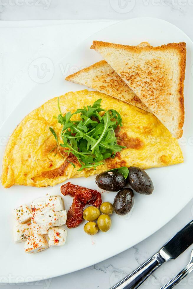 desayuno de huevos con carne, hierbas y gotas de salsa con un pan en un redondo plato parte superior ver foto