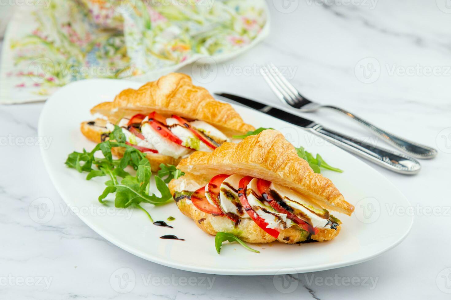 croissants with cheese, vegetables, cherry tomatoes and herbs photo