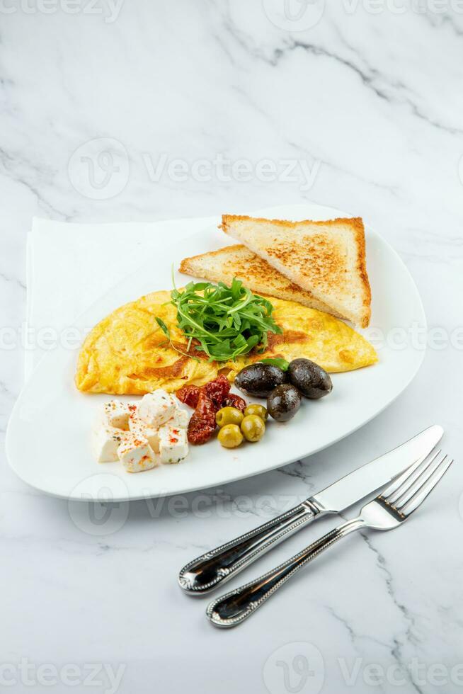 desayuno de huevos con carne, hierbas y gotas de salsa con un pan en un redondo plato lado ver foto