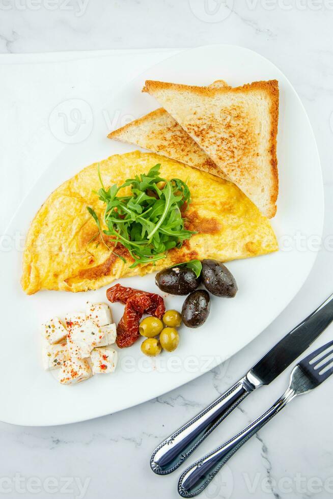 Breakfast of eggs with meat, herbs and drops of sauce with bread in a round plate top view photo