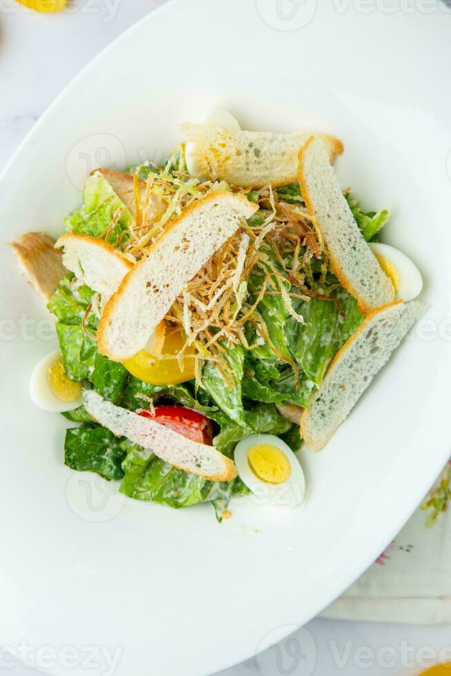 salad with quail eggs, cherry tomatoes, lettuce and breadcrumbs, top view photo