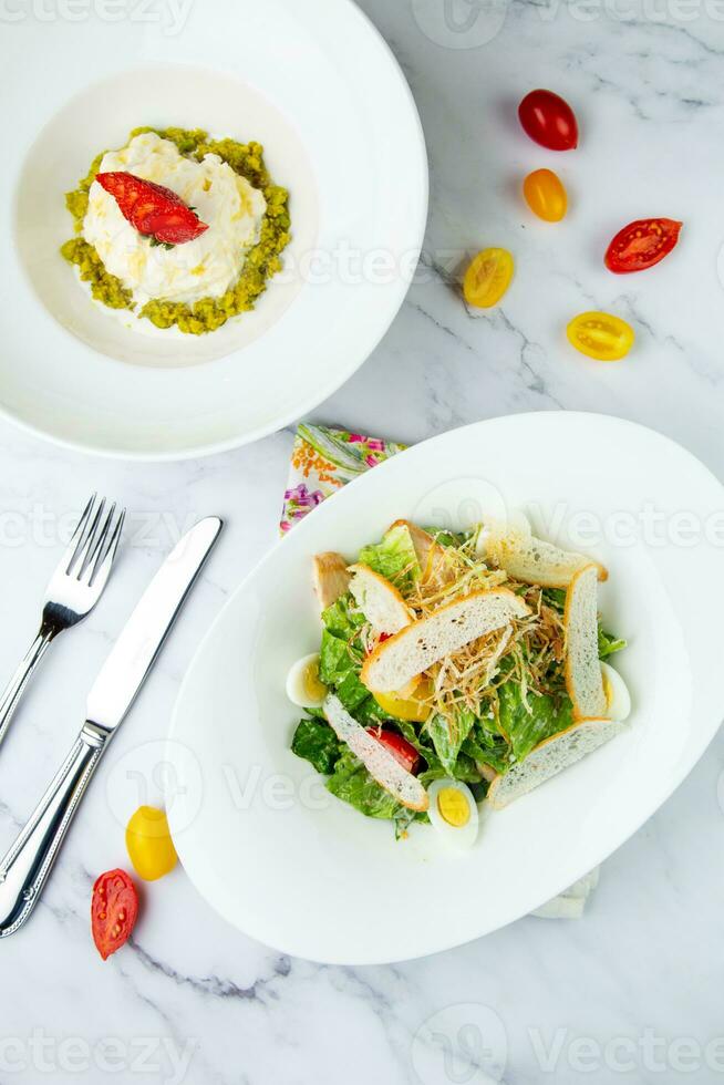 salad with quail eggs, cherry tomatoes, lettuce and breadcrumbs, top view photo