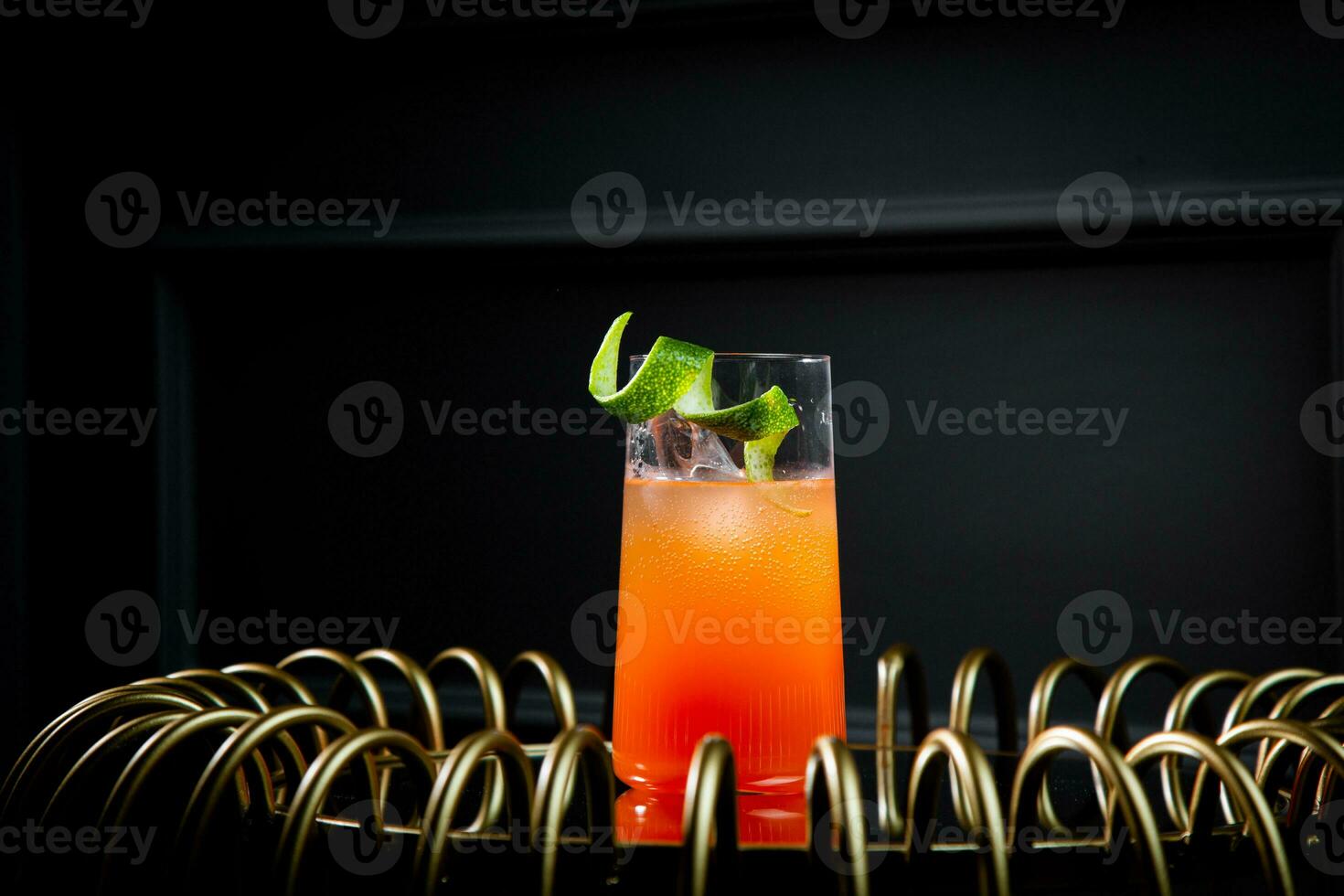 tropical cocktail with sunset gradient and citrus side view photo