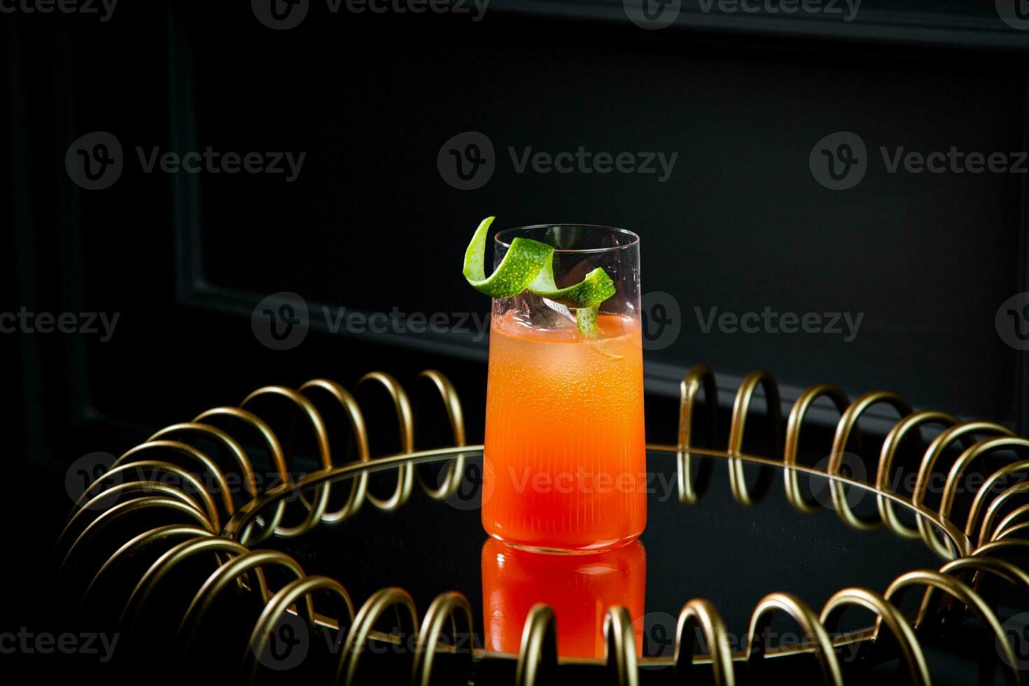 tropical cocktail with sunset gradient and citrus side view photo