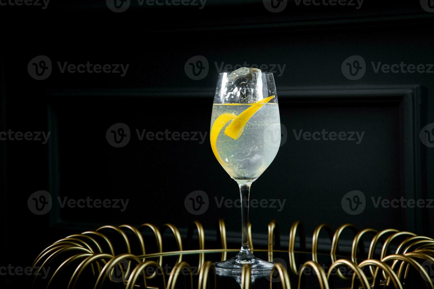 side view of transparent carbonated cocktail with lemon and ice photo