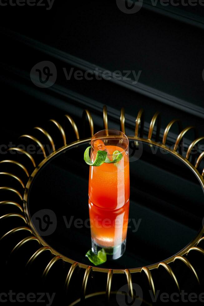 tropical cocktail with sunset gradient and citrus side view photo