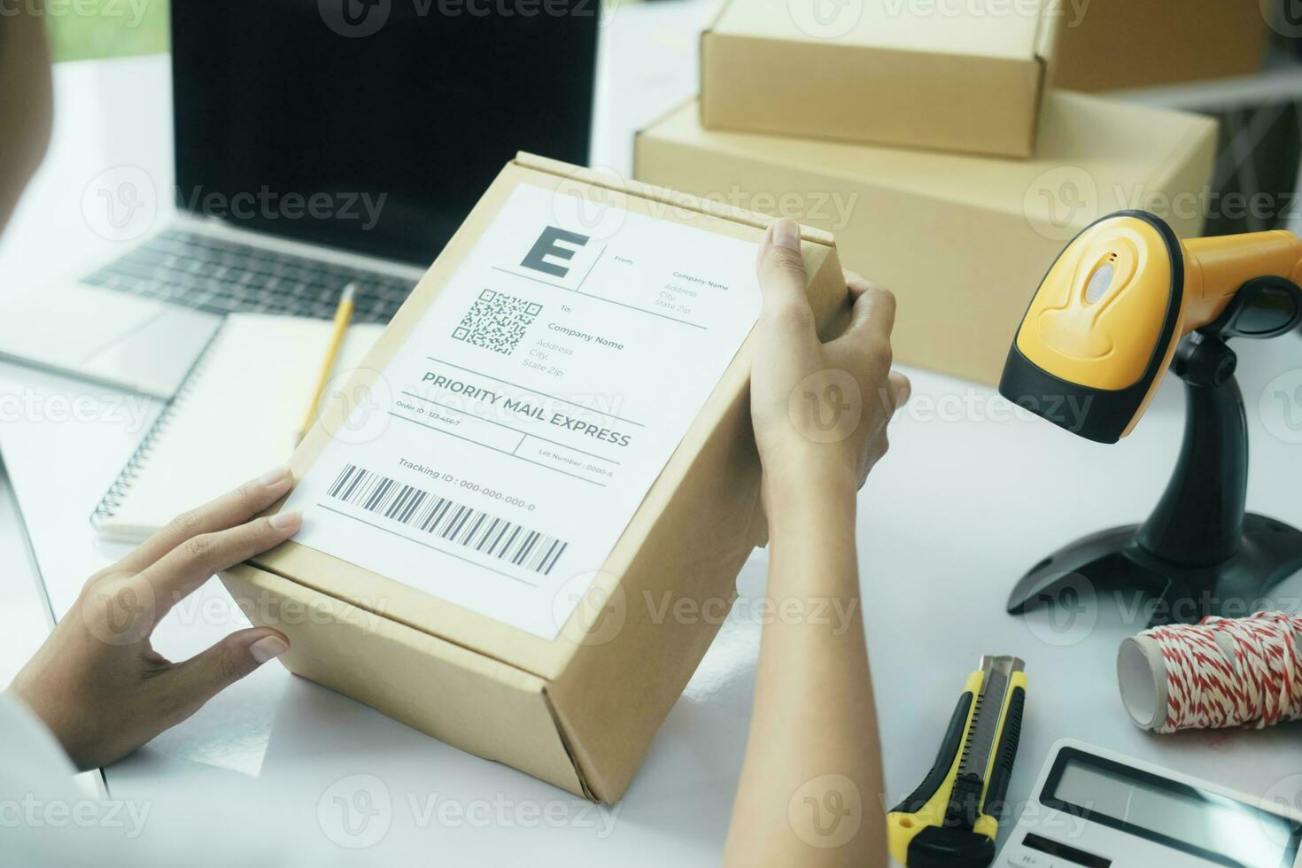 Young business owner putting shipping label on parcel. photo