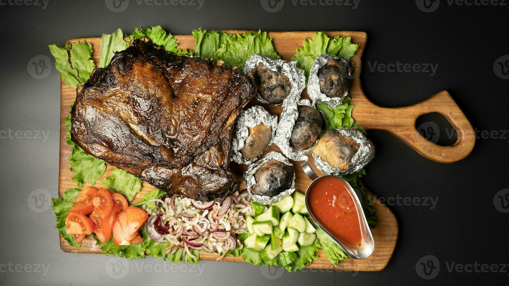 juicy smoked lamb thigh with sauce on a wooden board photo