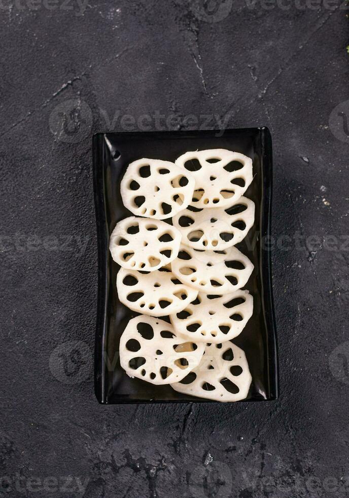 l exotic lotus root on a black plate. Garnish. View from above. Chinese cuisine, hotpot ingredient photo