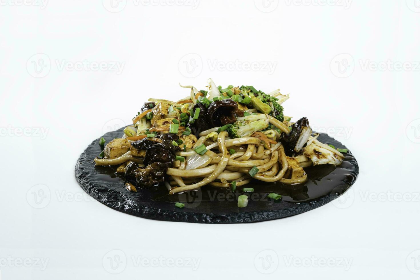 hot roasted wheat noodles with broccoli and tofu on the black plate photo