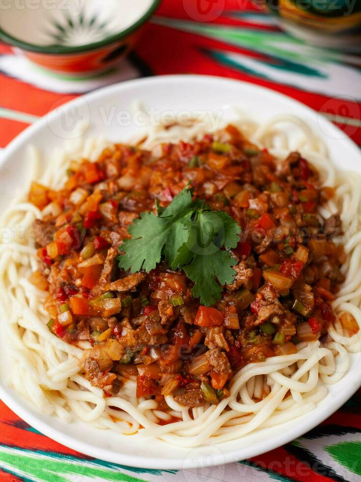 The oriental dish guiru lagman is homemade noodles fried with meat, vegetables and herbs. Eastern cuisine photo