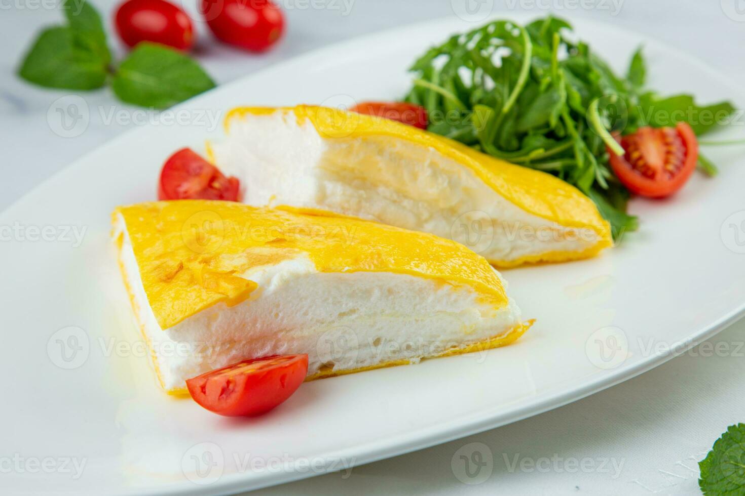 French tall omelette with arugula and cherry tomatoes side view photo