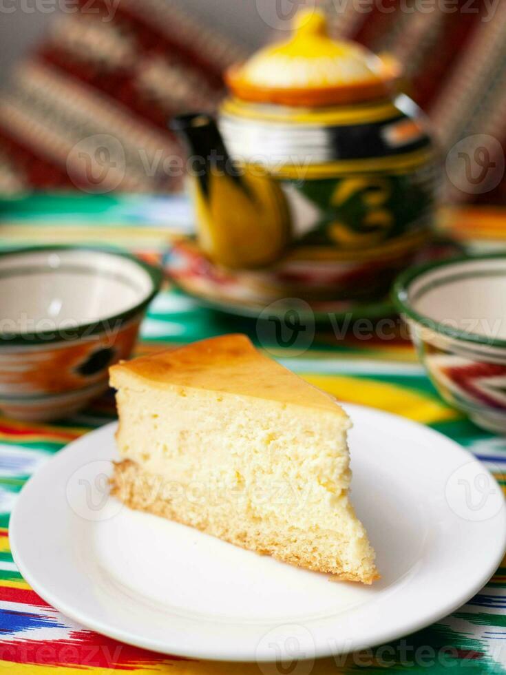 dessert chocolate cake with white butter cream in oriental style on a rooftop with a teapot and a cup for tea. photo