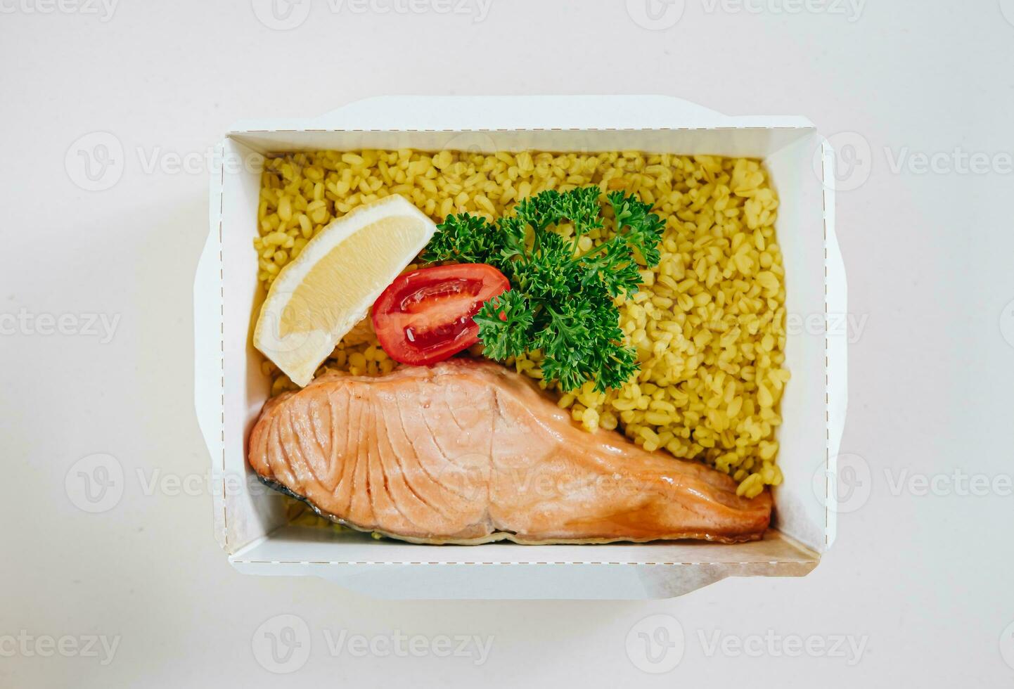 food in containers. proper nutrition, daily diet, weight loss. greens, tomato, lemon salmon steak with couscous side dish. Top view photo