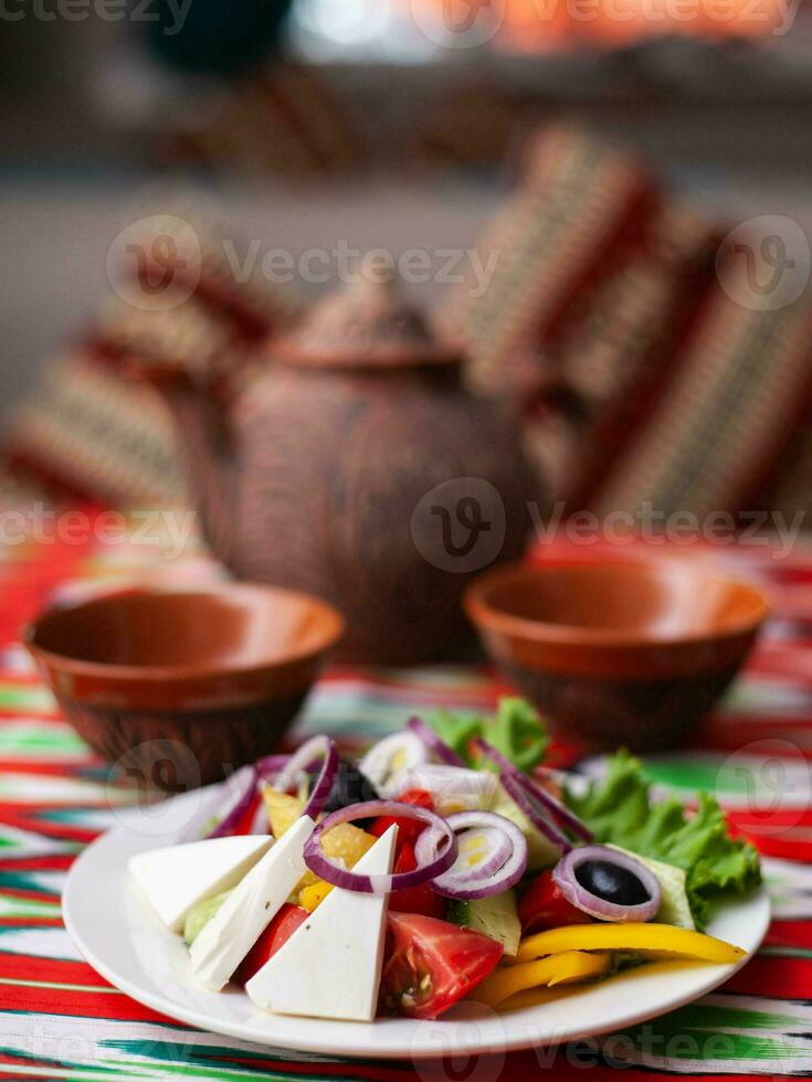 Vegetable slicing in Georgian style tomatoes, cucumbers, greens, Bulgarian pepper, cheese, onion. Asian style photo