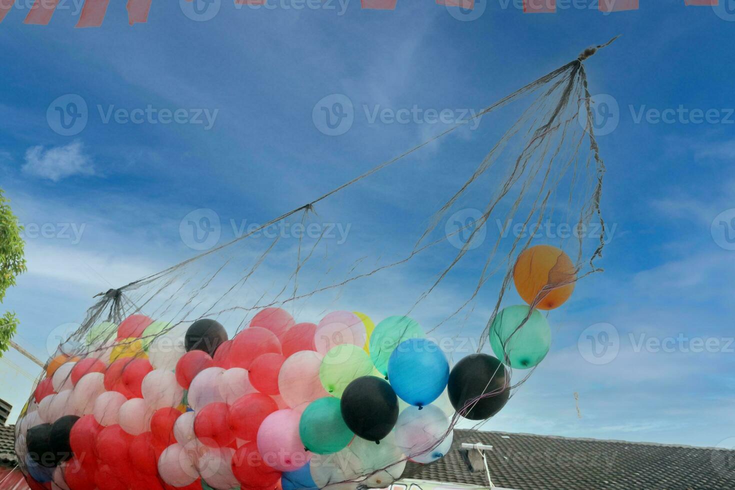 Collection of tied balloons with clouds photo