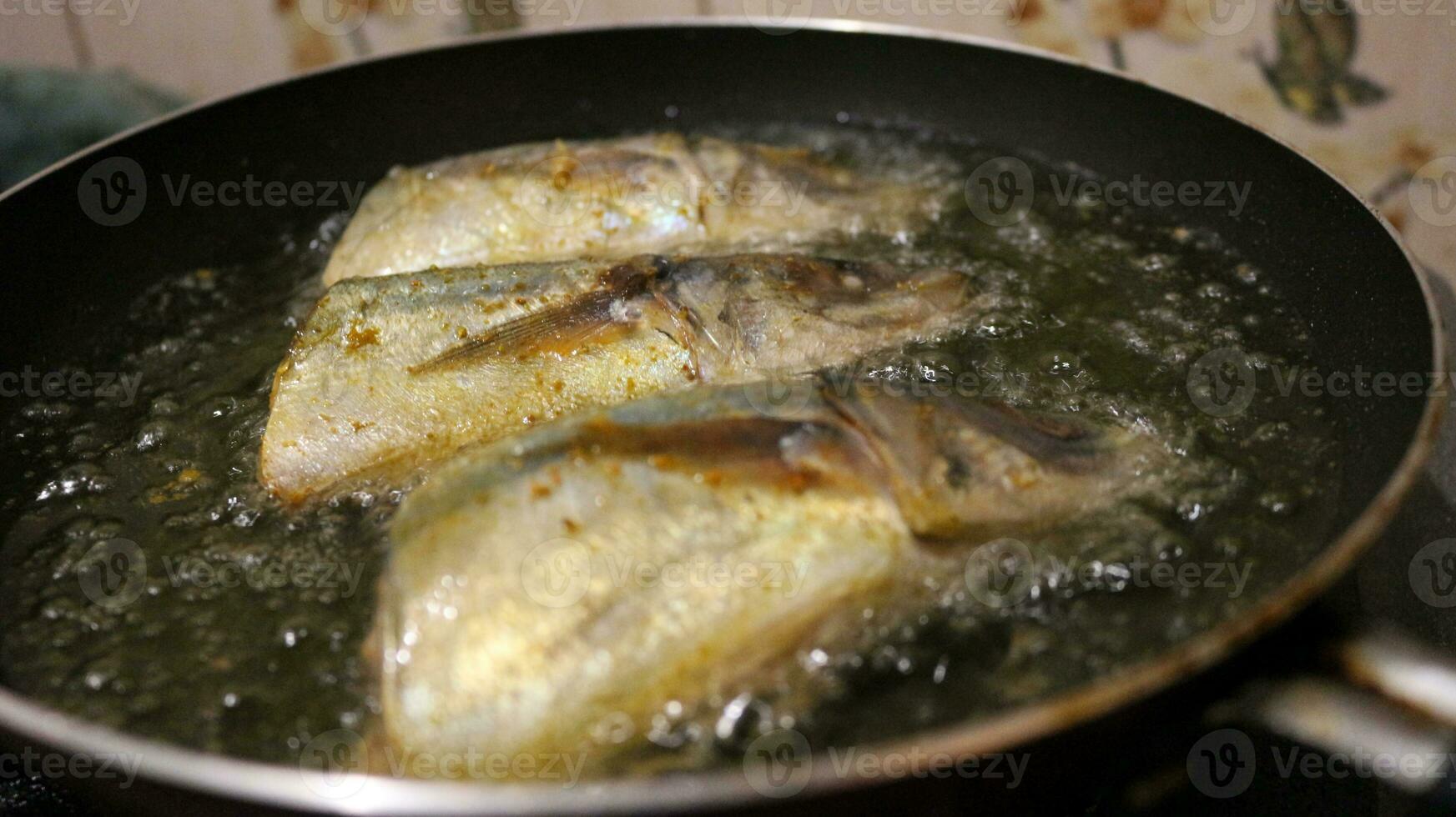 Close up of fish fried on a frying pan photo