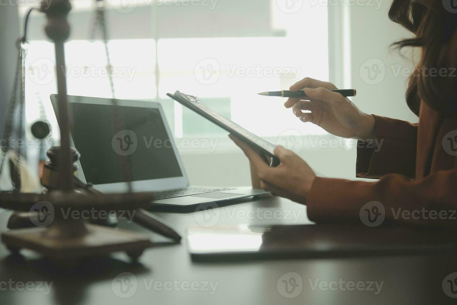 Business and lawyers discussing contract papers with brass scale on desk in office. Law, legal services, advice, justice and law concept picture with film grain effect photo