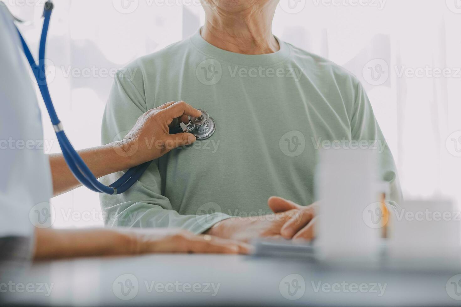 Mature Asian male doctor talking with his patient, explaining the procedure to old lady. photo