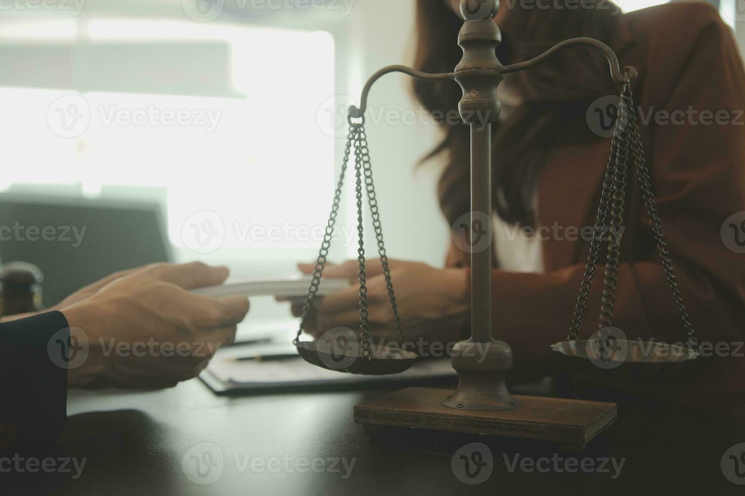 Business and lawyers discussing contract papers with brass scale on desk in office. Law, legal services, advice, justice and law concept picture with film grain effect photo