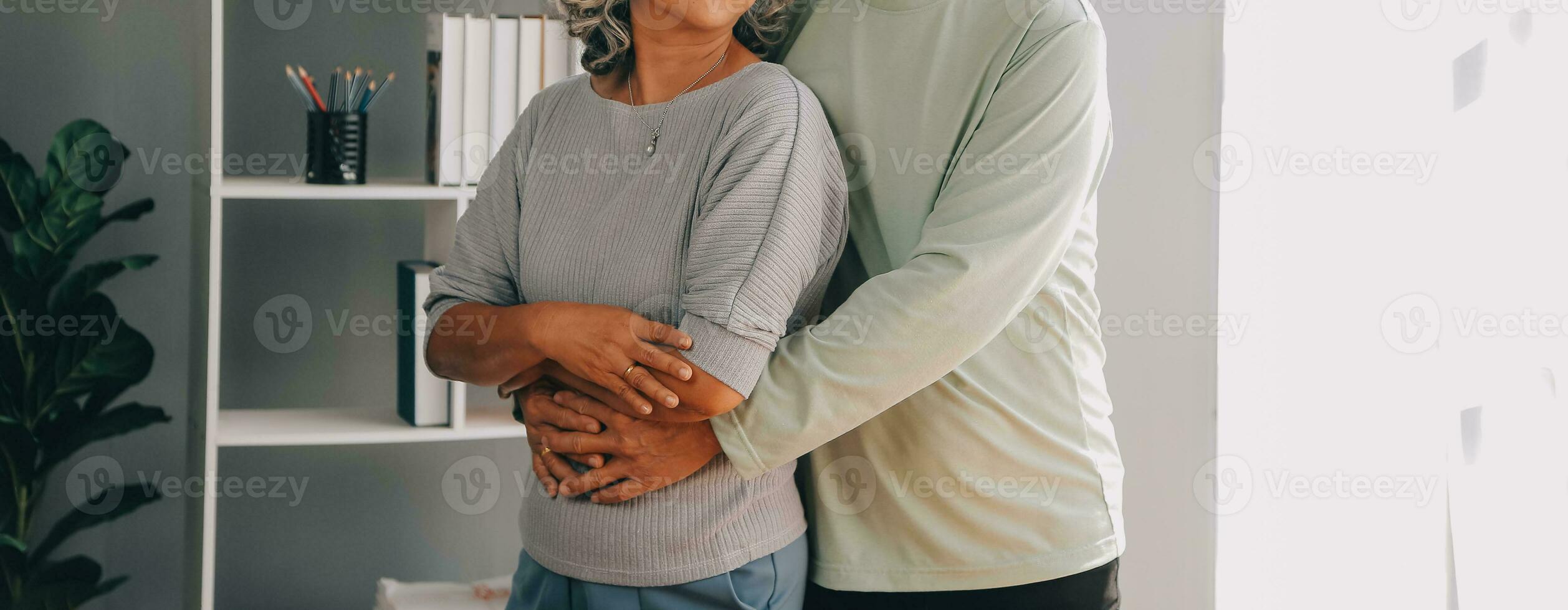 Embraced mature couple surfing the Internet on laptop at home photo