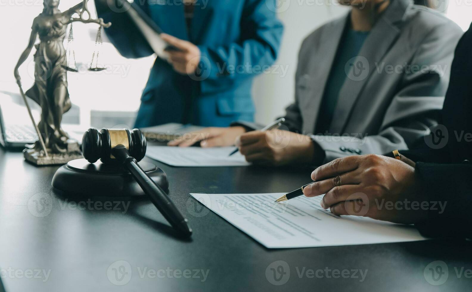 Male lawyer working with contract papers and wooden gavel on tabel in courtroom. justice and law ,attorney, court judge, concept. photo