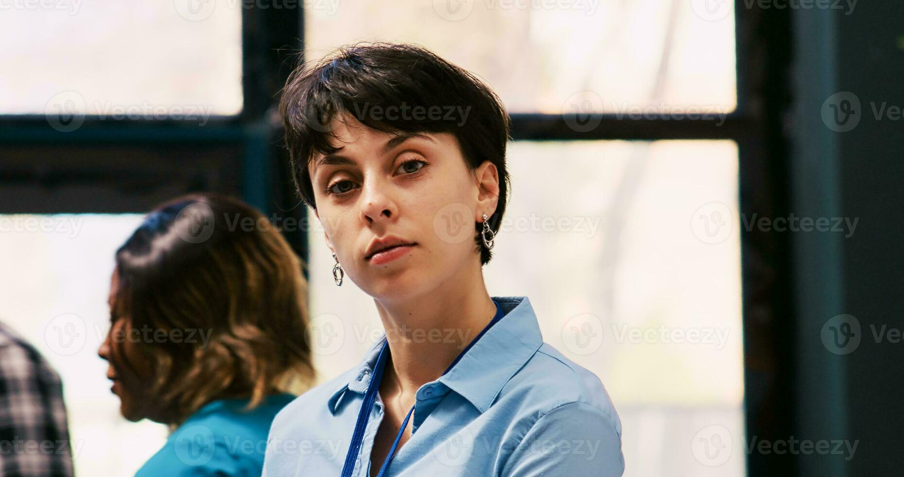 Cheerful employee arranging stylish clothes, working at modern boutique visual. Caucasian manager putting hangers with fashionable merchandise on racks in shopping centre. Fashion concept photo