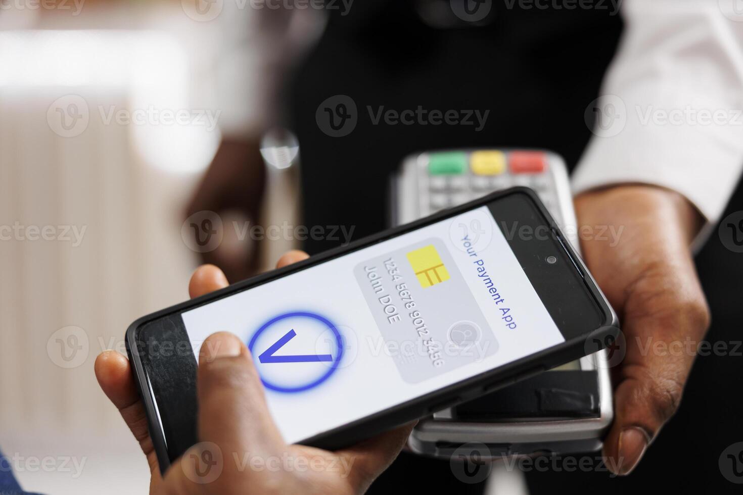 Close up of human hand holding smartphone using mobile nfc payment while paying for hotel services, contactless POS payment. People using banking app to pay via NFC technology, mobile wallet photo