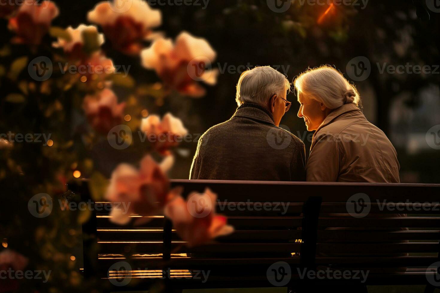 Elderly couple sitting on a bench in park, flowers all around, loneliness photo