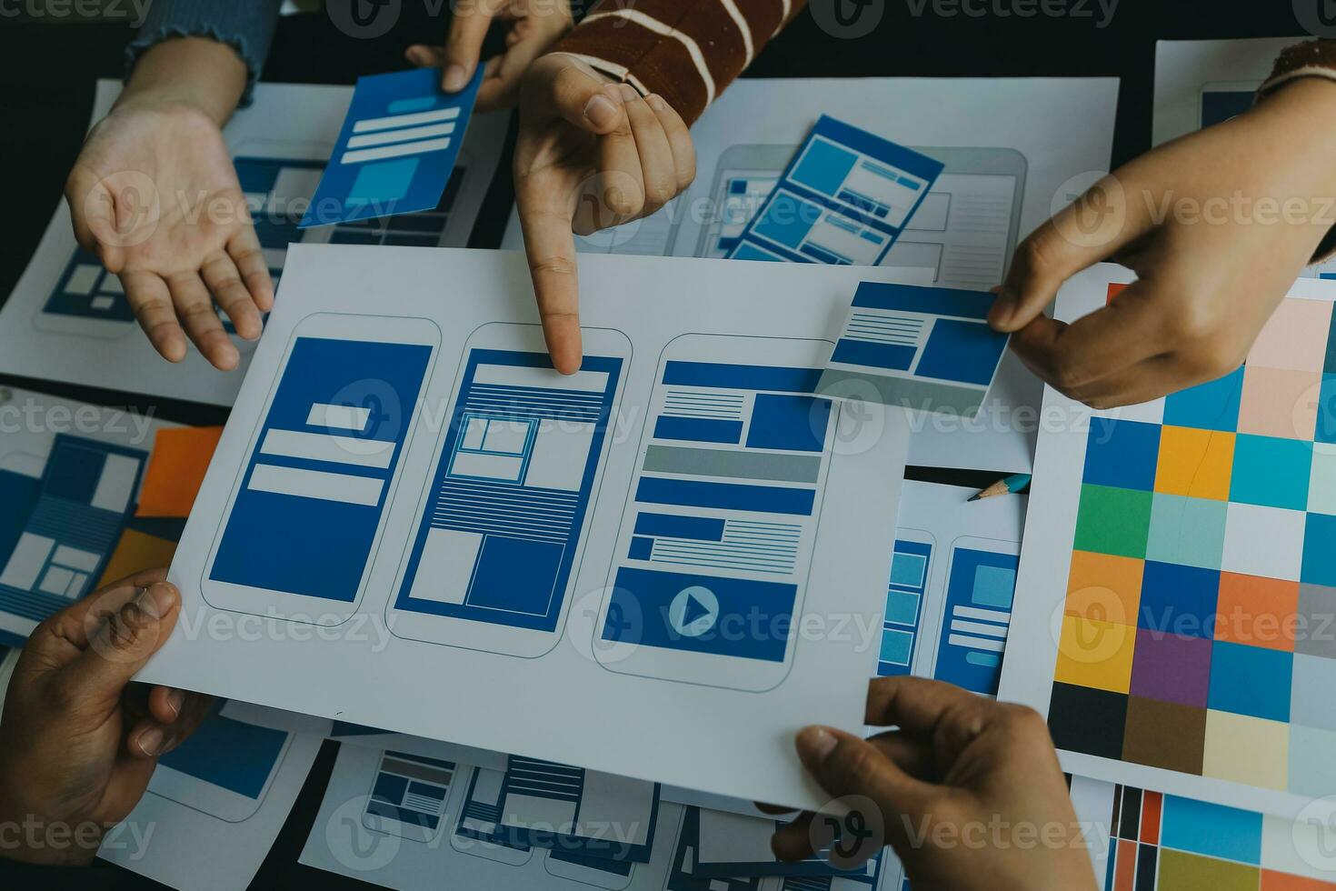 Close up ux developer and ui designer brainstorming about mobile app interface wireframe design on table with customer breif and color code at modern office.Creative digital development agency photo