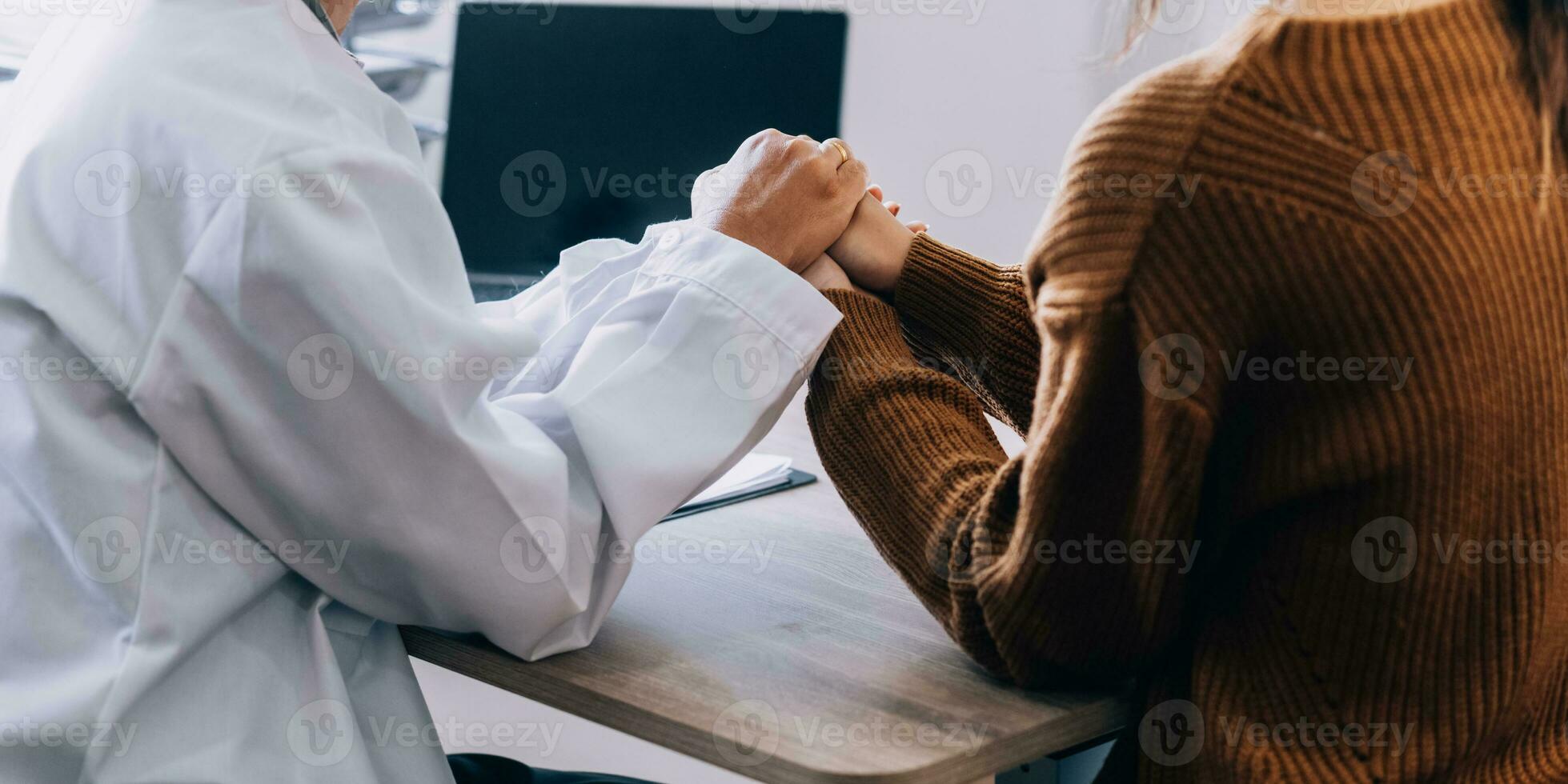 Young psychologist holding hand of her patient in need while consulting her after discussion of problem photo